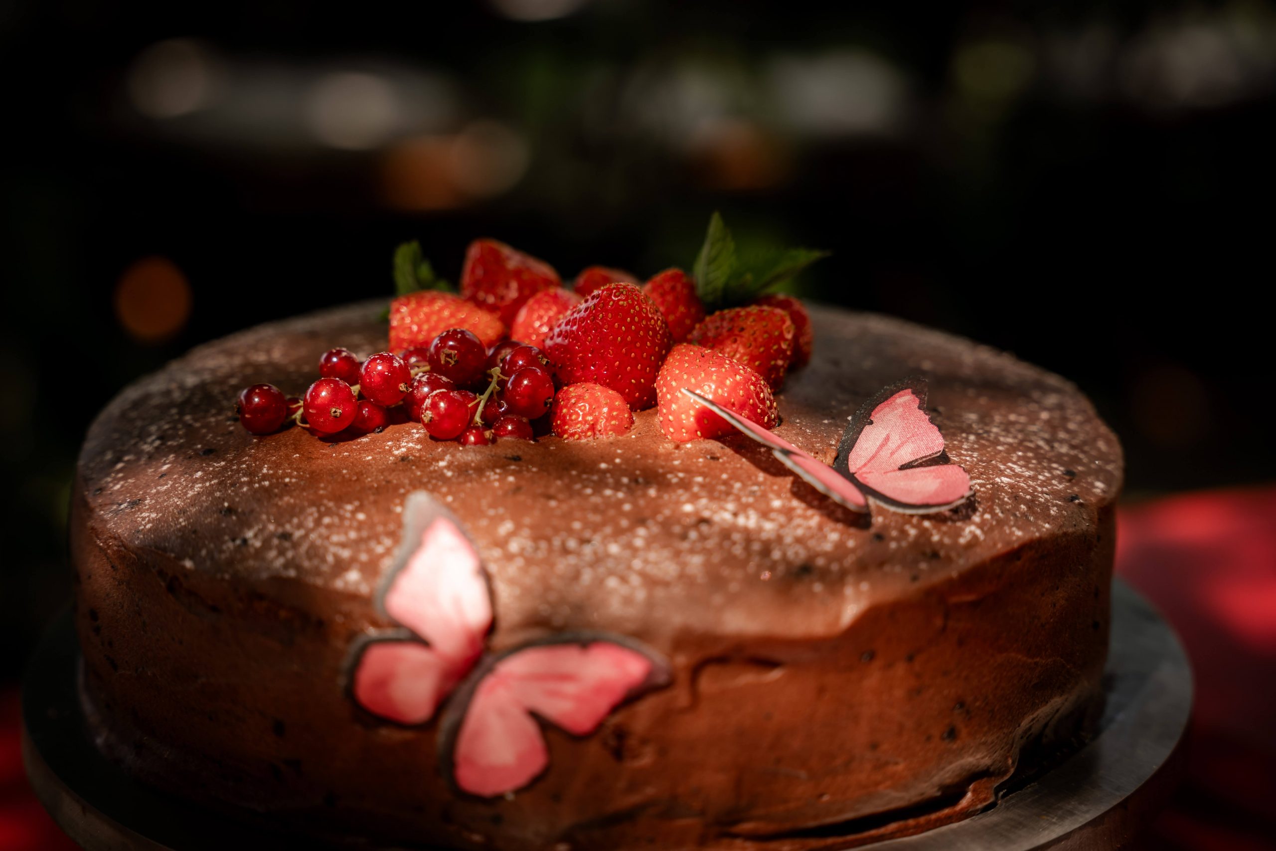 Eine schön angerichtete Hochzeitstorte mit Erdbeeren. Fotografiert von Anke Hartl von Echte Hochzeitsmomente